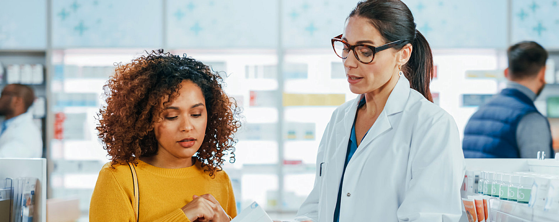 Pharmacist giving prescription to a young woman